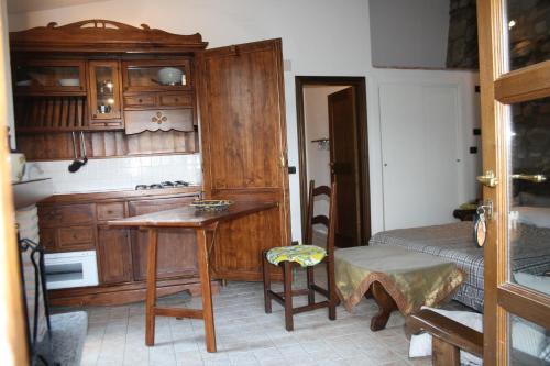 a kitchen with wooden cabinets and a table and a chair at Agriturismo Materno in Radicondoli