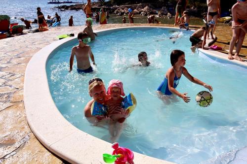 a group of people in a swimming pool at Camping Kozarica Mobile Homes in Pakoštane