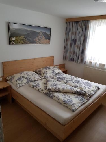 a bedroom with a bed with a wooden frame at Ferienwohnung Fringer in Obtarrenz