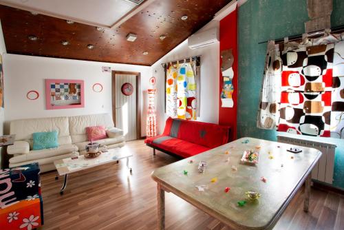 a living room with a red couch and a table at Anahuaska Art - Suites Temáticas in Panzares