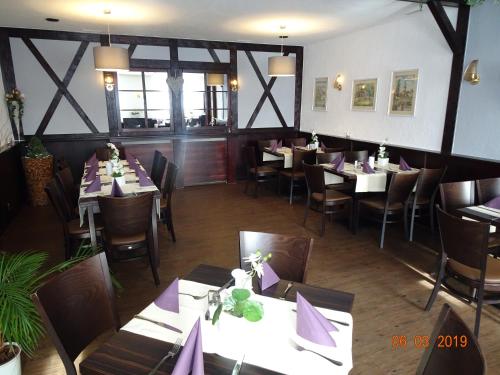 un restaurante con mesas y sillas con servilletas moradas en Gasthaus Stadt Bad Sulza, en Bad Sulza