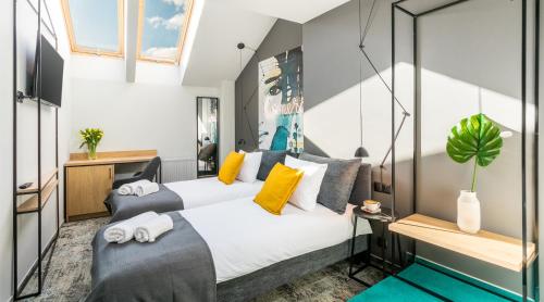 um quarto com 2 camas e almofadas amarelas em Camera Apartments em Cracóvia
