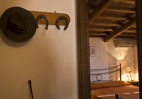 Habitación con cama y reloj en la pared en Agriturismo Il Melograno di Banditella, en Alberese