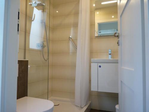 a bathroom with a shower and a toilet and a sink at Ferienapartment am See in Wettringen