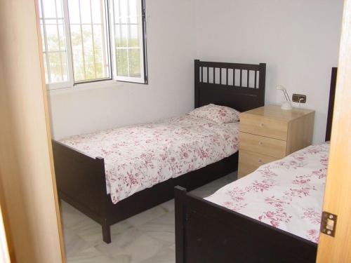 a bedroom with two beds and a dresser and window at Villa Mar - now with HEATED POOL! in Isla Canela