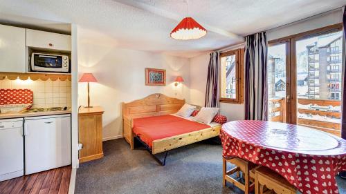 une petite chambre avec un lit et une table dans l'établissement Vacancéole - Résidence Vega, à Risoul