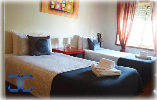 una camera d'albergo con due letti e asciugamani di Life in Porto Apartment by JC a Porto