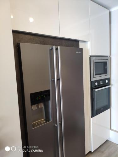 un réfrigérateur en acier inoxydable dans une cuisine avec un micro-ondes dans l'établissement appartement marseille velodrome, à Marseille