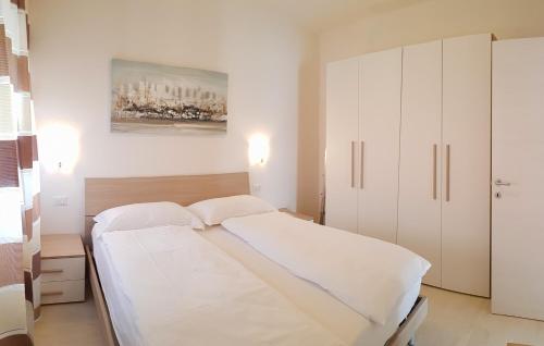 a white bedroom with a bed and cabinets at Casa Palanca Lake view apartment by Gardadomusmea in Tremosine Sul Garda