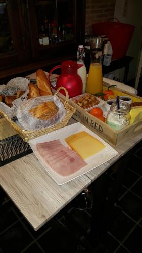 un tavolo con un mucchio di tipi diversi di pane di Guest house Adonis a Bruges