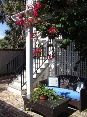 a bench sitting next to a staircase with pink flowers at Port d'Hiver Bed and Breakfast in Melbourne Beach