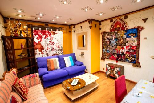 a living room with a purple couch and a table at Anahuaska Art - Suites Temáticas in Panzares
