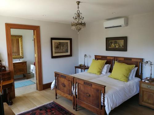 een slaapkamer met een groot bed met groene kussens bij Bakovenbay Luxury Suites in Kaapstad