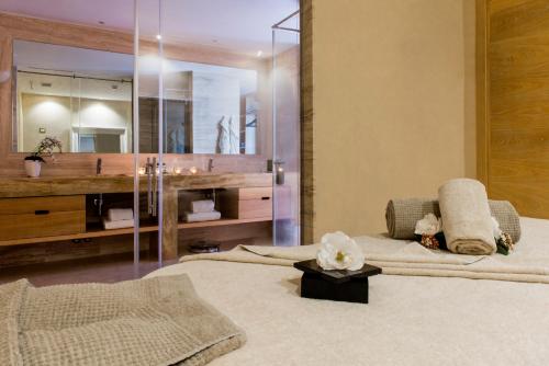 two beds in a room with a sink and a mirror at Castello di Velona Resort, Thermal SPA & Winery in Montalcino