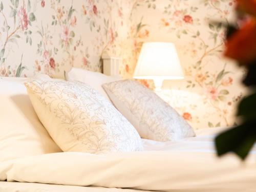 a bedroom with a bed with pillows and a lamp at Björkbackens Karaktärshotell in Vimmerby