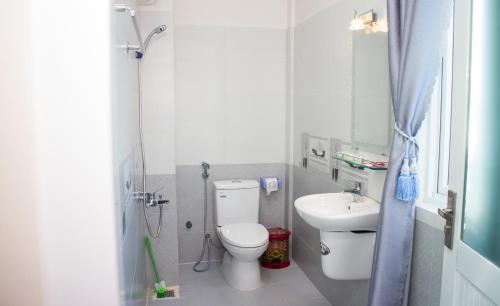 a small bathroom with a toilet and a sink at Hotel Nguyên Phước in Pleiku