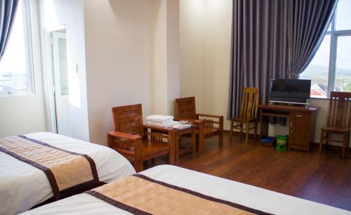 een hotelkamer met 2 bedden en een televisie bij Hotel Nguyên Phước in Pleiku