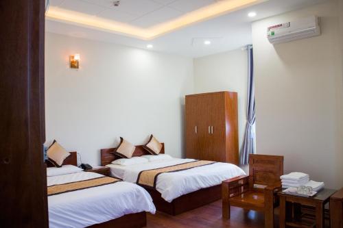 a hotel room with two beds and a window at Hotel Nguyên Phước in Pleiku
