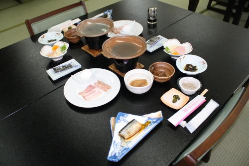 a black table with plates and bowls of food on it at Hotel Grand Toya in Lake Toya