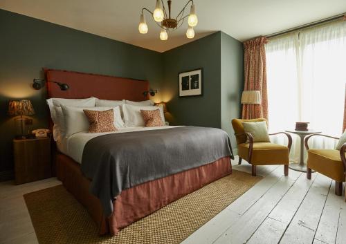 a bedroom with a large bed and a chair at Redchurch Townhouse in London