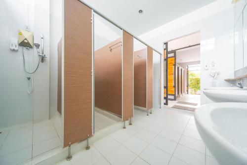 a bathroom with a row of stalls with sinks and mirrors at ChillHub Hostel Phuket in Bang Tao Beach