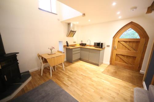 a kitchen with a table and a wooden door at The Well house in Ilfracombe