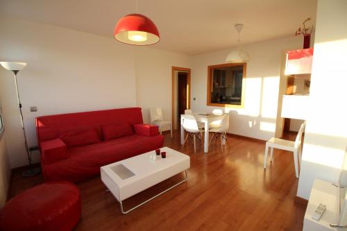 - un salon avec un canapé rouge et une table dans l'établissement Apart-rent Apartment Ancora 14º, à Empuriabrava