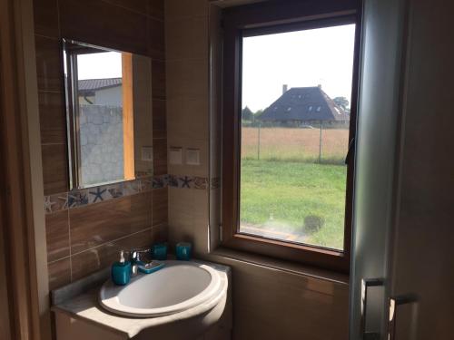 a bathroom with a sink and a window at Domki VIP dla rodzin Ustka in Ustka