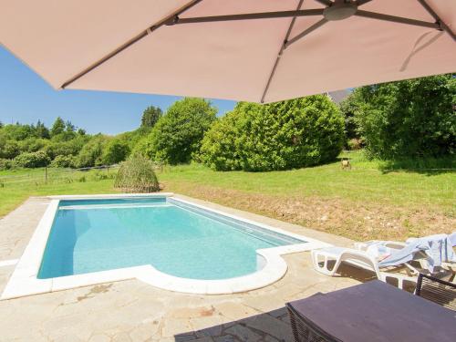 a swimming pool with an umbrella in a yard at Mansion with Private Pool in Aquitaine in Savignac-Lédrier