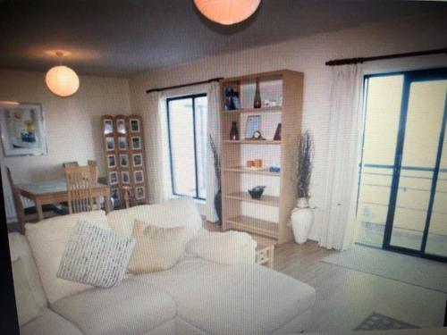 a living room with a white couch and a table at Beach Front Apt Portballintrae , Bushmills close to Royal Portrush Golf Club in Portballintrae