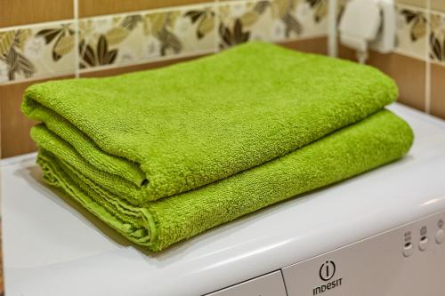 a green towel sitting on top of a washing machine at Апартаменты Абажур на Максима Горького in Kurgan