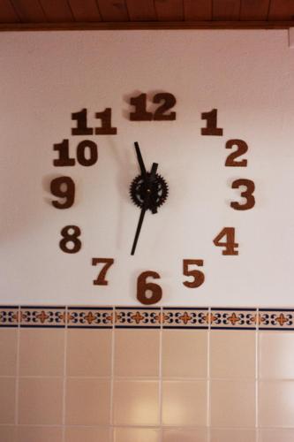a clock on top of a tiled wall at Hostel Nature in Zambujeira do Mar