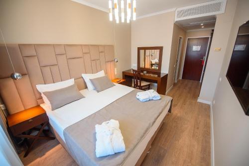 una camera da letto con un grande letto con asciugamani di Astana International Hotel a Almaty
