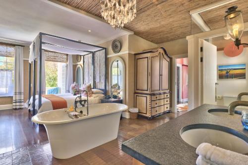 a bathroom with a tub and a bedroom with a bed at Hout Bay Manor in Hout Bay