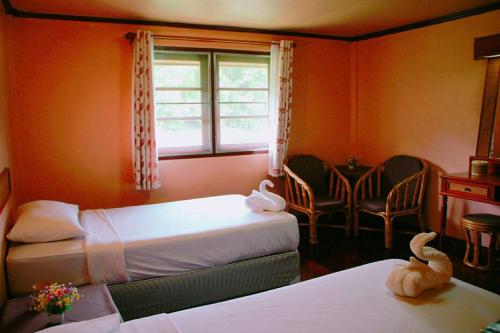 a hotel room with two beds and a window at River Kwai Park & Resort in Chongsadao