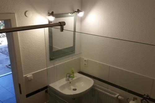 La salle de bains est pourvue d'un lavabo et d'un miroir. dans l'établissement FeWo Engler Bremen Neustadtstraße, à Brême