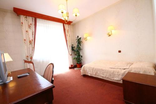 a hotel room with a bed and a desk and a desk at Restauracja i Pokoje Gościnne Verde in Sokółka