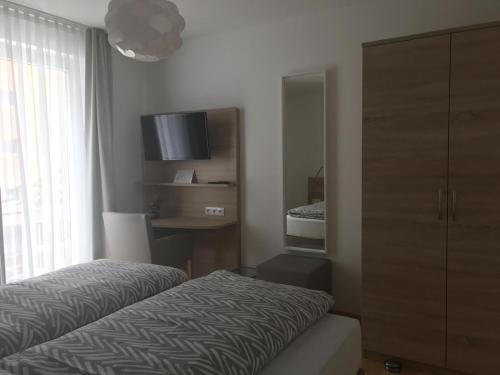 a bedroom with a bed and a dresser and a window at Espelkamp Gästehaus in Espelkamp