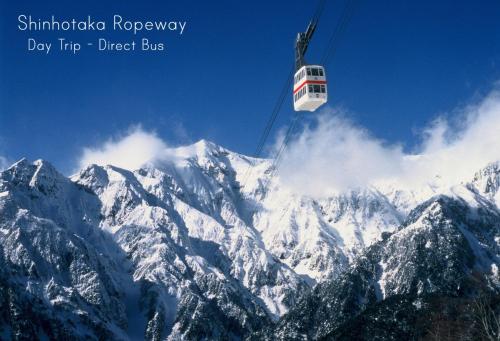 a ski lift flying over a snow covered mountain at K's House Takayama Oasis [2nd K's Hostel] in Takayama