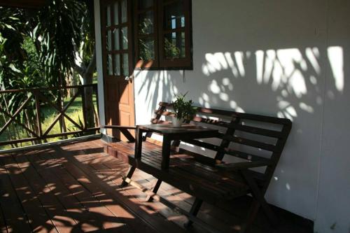 a wooden table and bench on a porch at River Kwai Park & Resort in Chongsadao