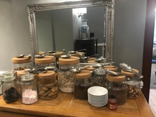 una mesa con tarros de comida y un espejo en The Hotel Commodore en Llandrindod Wells