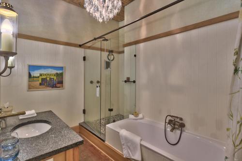 a bathroom with a tub and a sink and a shower at Hout Bay Manor in Hout Bay