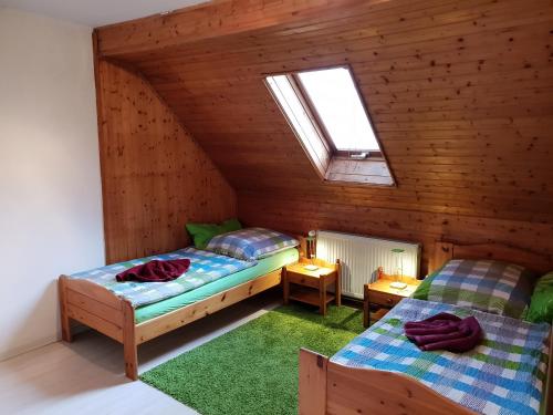 2 łóżka w pokoju na poddaszu w obiekcie Dudu's Gästehaus w mieście Diebach am Haag