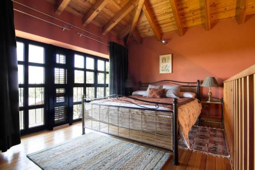 a bedroom with a bed in a room with windows at Hotel Sara De Ur in La Cabrera
