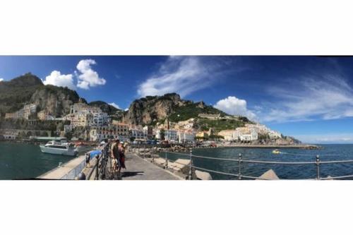 un gruppo di persone in piedi su un molo vicino all'acqua di Il Cuore di Amalfi ad Amalfi