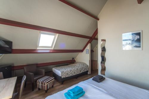 a small bedroom with two beds and a window at Hotel Faber in Zandvoort
