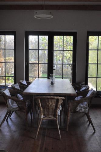 a dining room table with chairs and windows at Birchy Hills in Sitno