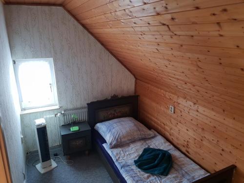 a small bedroom with a bed and a window at Dudu's Gästehaus in Diebach am Haag
