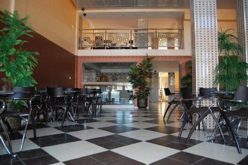 a restaurant with black chairs and a checkered floor at Hotel AMOUDOU فندق أمودو in Tiznit