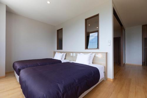 a hotel room with two beds and a mirror at 宮島離れの宿 IBUKU -Miyajima Hanare no Yado IBUKU- in Miyajima